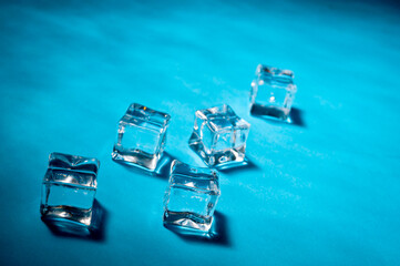 Clear ice cubes for cooling drinks on a blue background.