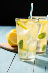 Glass of fresh lemonade on blue wooden background