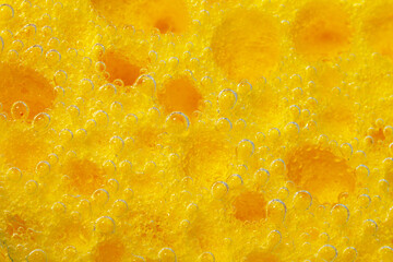 Texture of a sponge in water, close-up macro. The concept of washing dishes or cleaning cars. Abstract Yellow Wallpaper