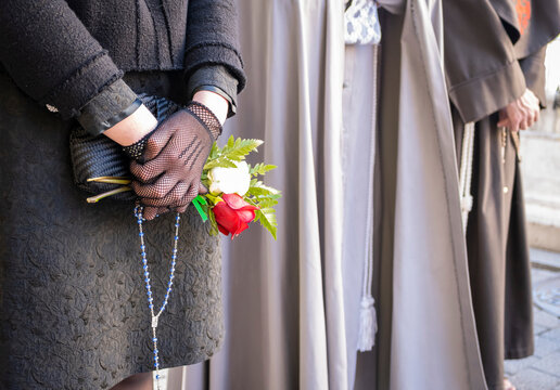 Semana santa Valladolid, detalle de motivo floral en manos de mujer durante el sábado santo