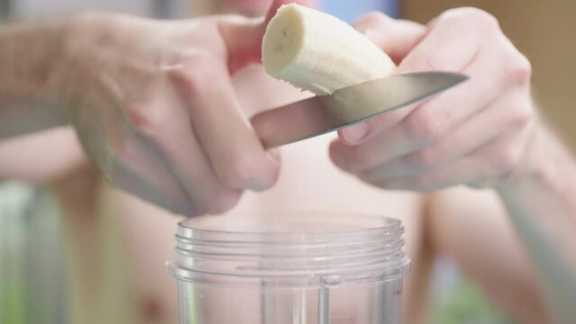 Headless nude male person cut banana for protein milkshake smoothie 4K