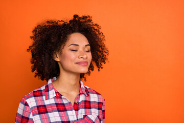 Photo of millennial wavy lady closed eyes wear red shirt isolated on orange color background