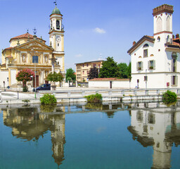 Obraz premium The old buildings in Gaggiano reflected in the Naviglio Grande canal, ancient waterway to Milan.Italy