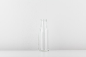 Empty glass bottle without cap. Bottle for milk and water isolated on white background.