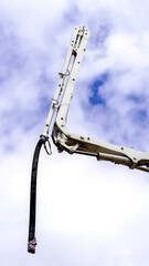 A hose of concrete mixer truck with a sky background