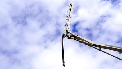 A hose of concrete mixer truck with a sky background