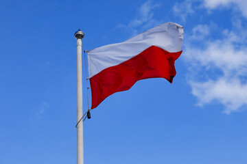 Poland flag on the blue sky background.