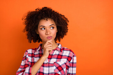 Photo of unsure millennial brunette lady look promo wear plaid shirt isolated on orange color...