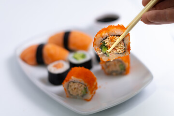 Sushi plate on white background. Makizushi. Delicious sushi rolls on white plate with chopsticks and wasabi. Maki