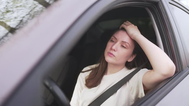 Anxiety and stress. Woman driver behind the wheel of the car is upset. Crisis and depression in life 4K 10 BIT