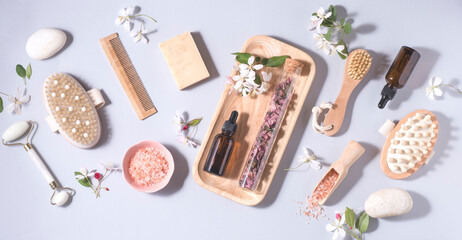Fototapeta na wymiar Natural cosmetics product background, banner with small spring-summer flowers . Serum or oil and cosmetic skin care, roller, zero waste, eco friendly bathroom and spa accessories, flowers aromatherapy