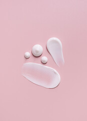 cosmetic smears cream texture on pastel pink background	
