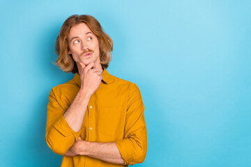 Portrait of attractive hesitant doubtful long-haired guy making decision copy space isolated over bright blue color background