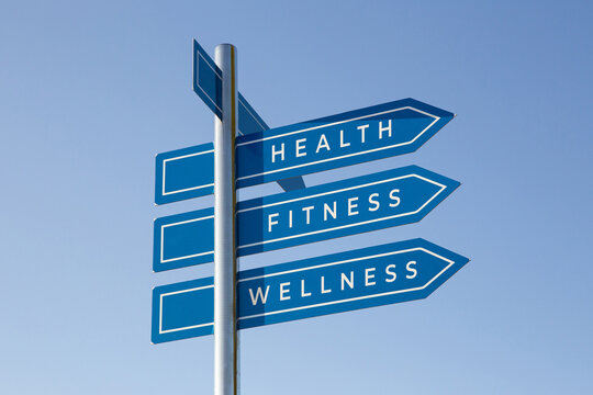 Naklejki Health, fitness, wellness on signpost on blue sky. Healthy lifestyle concept