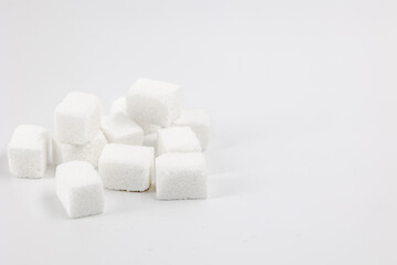 Fototapeta na wymiar Lots of sugar cubes piled up on a white background close-up
