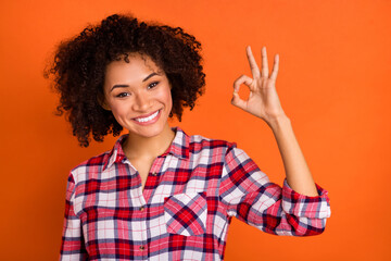 Photo of nice young brunette lady show okey wear red shirt isolated on orange color background