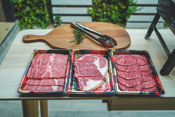 Fresh beef sliced for steak or grilled barbecue with beef tong on cutting board. meat tongs on a cutting board with Sliced fresh meat for steaks or barbecue grilled party at home.