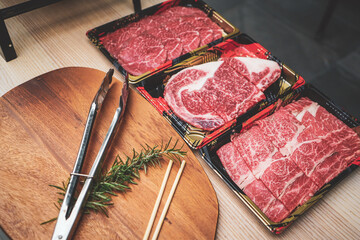 Fresh beef sliced for steak or grilled barbecue with beef tong on cutting board. meat tongs on a cutting board with Sliced fresh meat for steaks or barbecue grilled party at home.