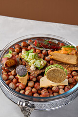 Appetizers set on luxury plate with hazelnut. Creative platter of appetizers from inspirational chef. Salmon cheesecake, fish tartar, pastrami crocket, liver pate, baked mini-paprika