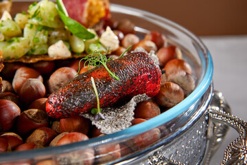 Appetizers set on luxury plate with hazelnut. Creative platter of appetizers from inspirational chef. Salmon cheesecake, fish tartar, pastrami crocket, liver pate, baked mini-paprika