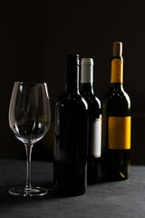 Bottles of white and red wine on a dark background