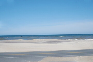 Fototapeta na wymiar Sandy Road, Dunes, Beach, Ocean, Waves, Flock of Black Birds on Water and Sunlgitht