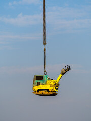Ramming equipment hanging on chain on blue sky clouds background