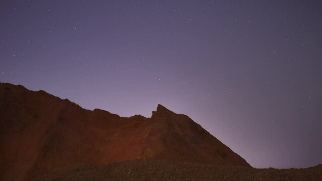 4K Time-Lapse Video motion of night sky with circular star trails over the rock formations mountains foreground. Mae Moh, Lampang, Thailand.