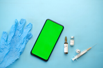 top view of coronavirus vaccine , syringe and smart phone on table 