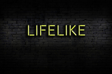 Neon sign. Word lifelike against brick wall. Night view