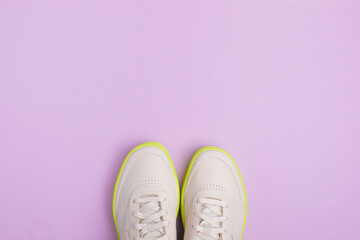 beige neon-soled sneakers on color background - Image