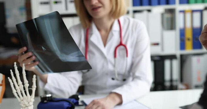 Doctor examines x-ray of patient with broken arm