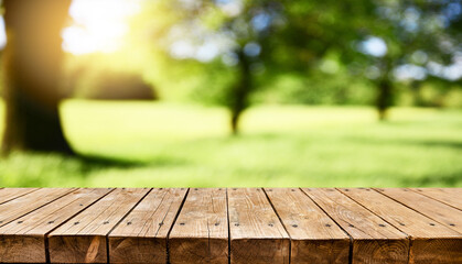 Empty old wooden table with fresh green spring garden in background