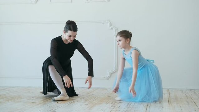 Young girls from ballet dancing ballet in white studio. Pretty graceful ballerinas doing elements of classical ballet - arts concept 4k footage