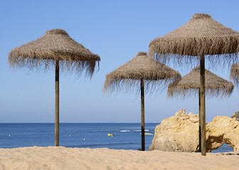 Tropical sun umbrellas on the Algarve coast - Portugal 