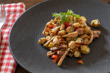garlic squid salad in a plate on a wooden table