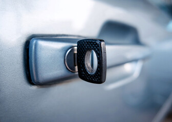 key inserted in the doorknob of a car, close-up of the key in the metallic door