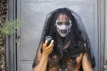 Spooky widow holding a black apple