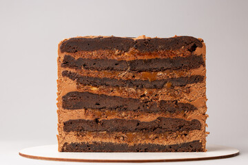 On a white background, a sweet pastry cake is cut in half, the cake is cut in half, the filling and biscuits are visible.Catalog demonstration.