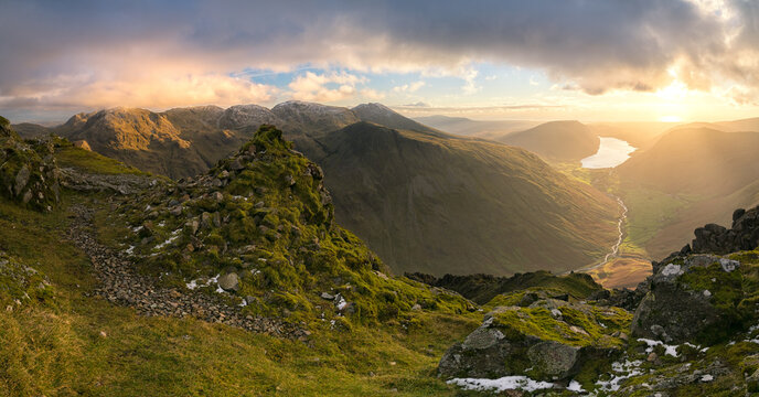 Panorama from the summit of Great Gable, with dramatic cloud above as the sun beigns to set for the evening, illuminating the valley