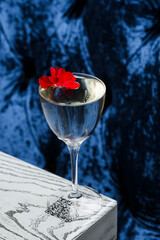 Drinking glass of daiquiri cocktail and summer flowers on wooden desk outdoors. Summer refreshing alcoholic citrus cocktail.