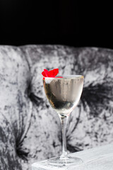 Drinking glass of daiquiri cocktail and summer flowers on wooden desk outdoors. Summer refreshing alcoholic citrus cocktail.