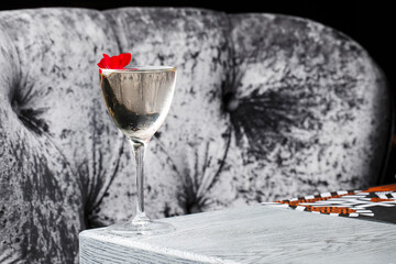 Drinking glass of daiquiri cocktail and summer flowers on wooden desk outdoors. Summer refreshing alcoholic citrus cocktail.