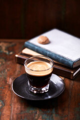 Coffee in glass cup on rustic wooden background