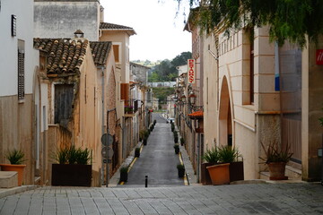 Fototapeta na wymiar Straßenfotografie in Sant Llorenç des Cardassar, Mallorca. Blick in eine enge Straße mit alten Häusern.