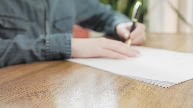 Close up of female client's hands signs the contract and receives the keys from the lawyer. The concept of insurance, mortgage and rental of real estate.