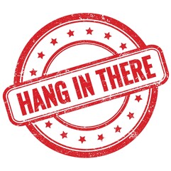 HANG IN THERE text on red grungy round rubber stamp.