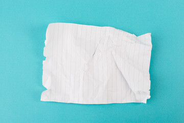 Crumpled empty paper with lines on a blue colored background, wrinkled memo card, copy space, note...