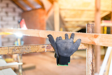 Construction rubberized black gloves torn hang on scaffolding at a construction site close-up