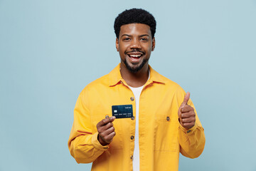 Young smiling cheerful happy fun man of African American ethnicity 20s wearing yellow shirt hold in...